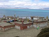 Tibet Kailash 07 Manasarovar 01 Seralung with lake in background We drove the Lake Manasarovar Kora in one day, following dirt roads around the lake and stopping at monasteries en route. Our first stop on the Kora was at Seralung Gompa, at the northeast corner of the lake. Some of the Gompas religious property, thrown into the lake during the Cultural Revolution, has been recovered. The Gompa was rebuilt in 1984. Guru Rinpoche (Padmasambhava) and Shakyamuni are the main images, and colourful masks adorn the shrine.